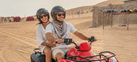A couple riding a quad bike during a private desert experience