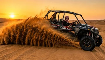 Polaris dune buggy driving through sand at sunset on a private Abu Dhabi evening desert tour