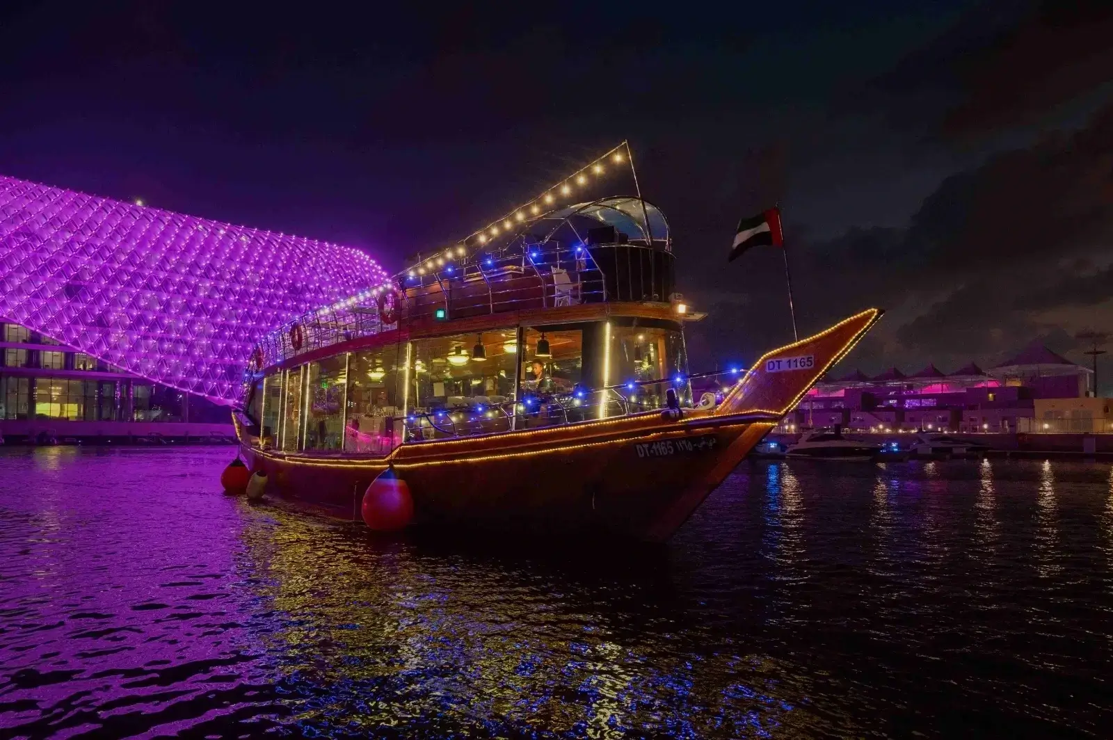 Abu Dhabi dhow cruise sailing along the yas marina passing W hotel illuminated canopy lights