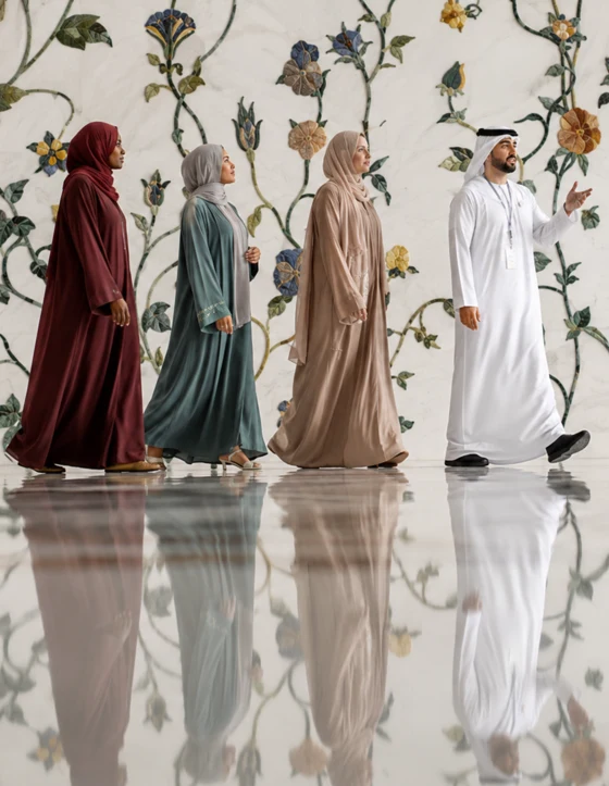 Emirati guide leading guests through Sheikh Zayed Grand Mosque in Abu Dhabi