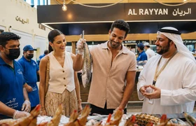 Visitors exploring a traditional Abu Dhabi fish market with an Emirati guide