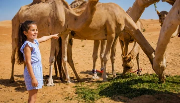 Guest enjoying a camel trekking experience in the Abu Dhabi desert