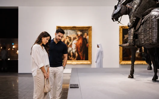 Couple viewing sculptures and artworks inside Louvre Abu Dhabi