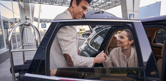 Traveller boarding a modern private vehicle for an Abu Dhabi city tour