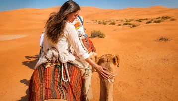 Guests visiting camels during an Abu Dhabi morning desert tour