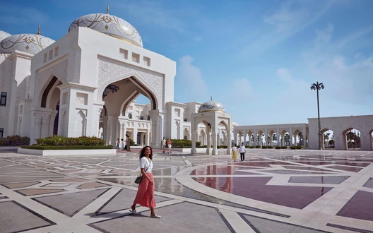 Visitor walking through the grand courtyard and ornate entrance of Qasr Al Watan in Abu Dhabi