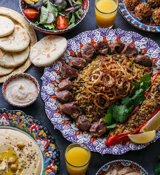 Traditional Middle Eastern food platter with rice, meat, hummus, and bread
