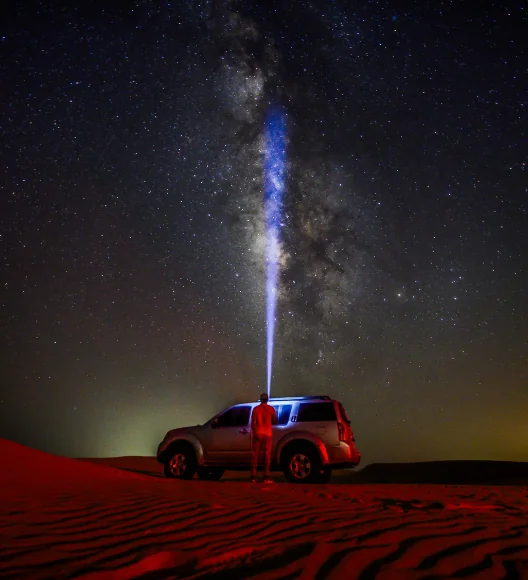 4x4 vehicle in desert under Milky Way during night desert safari experience