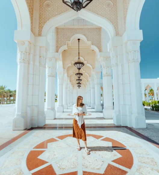 Visitor relaxing at Abu Dhabi Corniche with city skyline and palm trees