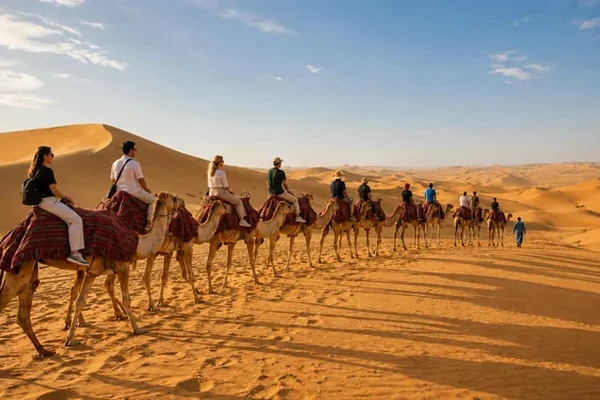 Camel caravan trekking across the dunes near Abu Dhabi