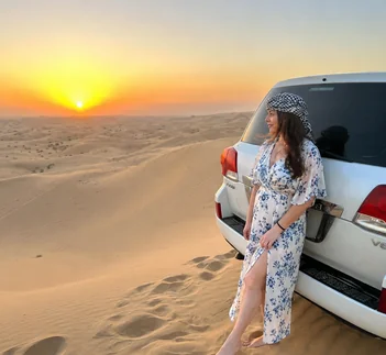Traveller photographing 4x4 vehicles crossing golden dunes during an Abu Dhabi desert safari, destination guide by Martin Muthugumi for Arabiers