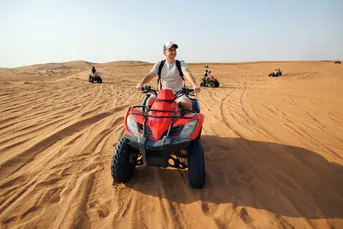 Traveller riding across the Abu Dhabi desert on an off road quad bike adventure arranged by Mujeeb Rahman for Arabiers Holidays