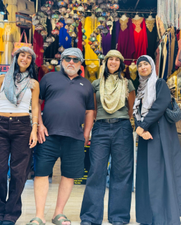 Khadija Nasir with Arabiers Holidays guests trying on traditional headscarves at a souk shop in old Dubai