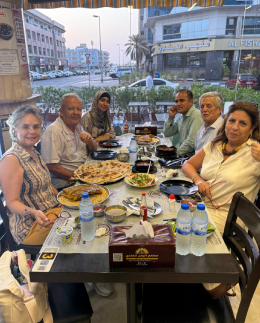 Khadija Nasir with an Arabiers Holidays tour group sharing a traditional mandi meal at a Yemeni restaurant in Deira, Dubai