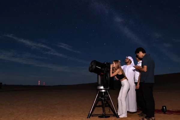 Guests viewing planets through a telescope with Mahmood Hasan