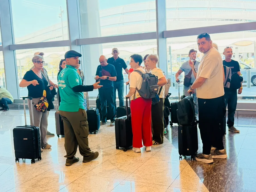 Khurshed Kamalov of Arabiers Holidays meeting a tour group with luggage at Zayed International Airport arrivals