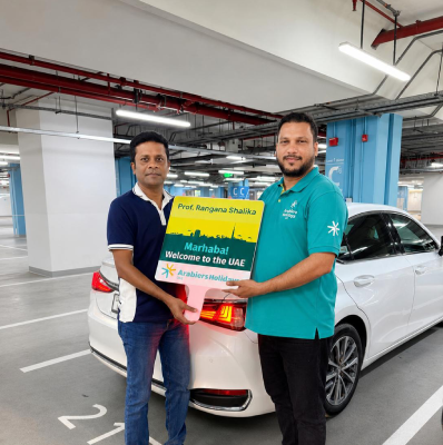 Sohail Ahmed welcoming an arriving Arabiers Holidays guest in Dubai with a 'Marhaba,  Welcome to the UAE' meet-and-greet board