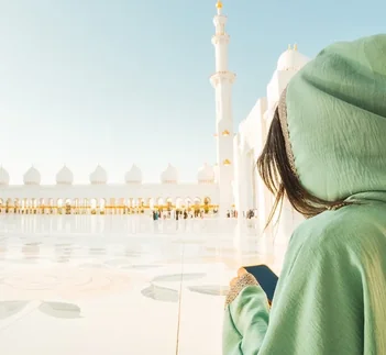 Visitor checking phone at Sheikh Zayed Grand Mosque, UAE Grace Period guide by Martin Muthugumi for Arabiers