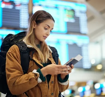 Traveller checking passport and phone at the airport, UAE Overstay Fine guide by Martin Muthugumi for Arabiers