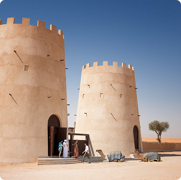 Luxury desert camp wedding venue in Abu Dhabi featuring traditional Arabian architecture and camels in desert setting