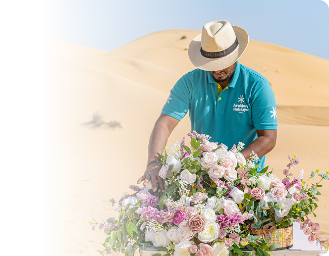 Arabiers Holidays UAE team arranging luxury floral décor for a desert wedding venue in Dubai sand dunes