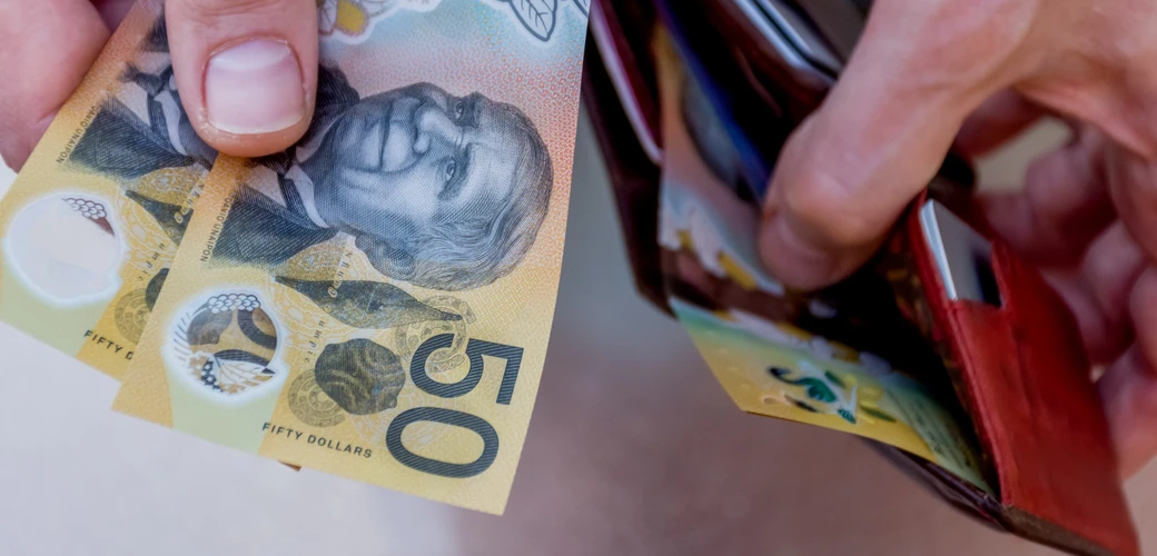 Australian dollar banknotes being taken from a wallet
