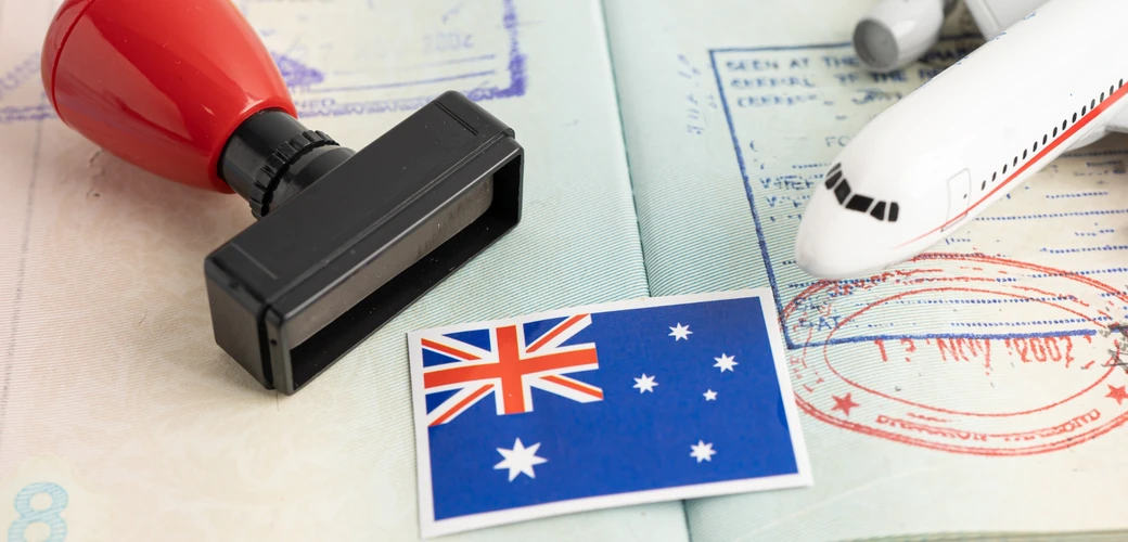 Australian flag on a passport with an immigration stamp and model aeroplane