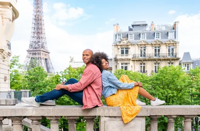Couple visiting Paris with the Eiffel Tower for Europe hotel booking from the UAE through Arabiers travel agency