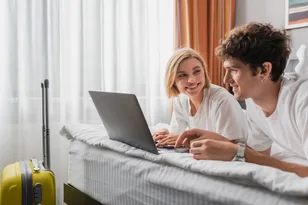 Travellers comparing hotel options on a laptop for UK hotel booking support by Arabiers UAE travel agency