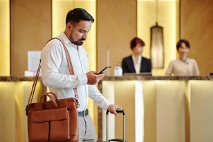 Traveller with luggage at a hotel reception for India hotel booking support by Arabiers UAE travel agency