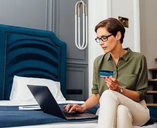Traveller paying online from a hotel room, selected by Arabiers to explain Dubai payment support for overseas hotel bookings