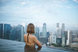 Traveller viewing Singapore city hotels from a rooftop pool, selected by Arabiers for Singapore hotel booking guidance from the UAE