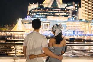Couple viewing Singapore Marina Bay hotels at night, selected by Arabiers for Singapore hotel booking guidance from the UAE