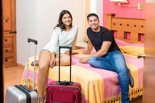 Couple with luggage in a hotel room for India hotel booking support by Arabiers UAE travel agency
