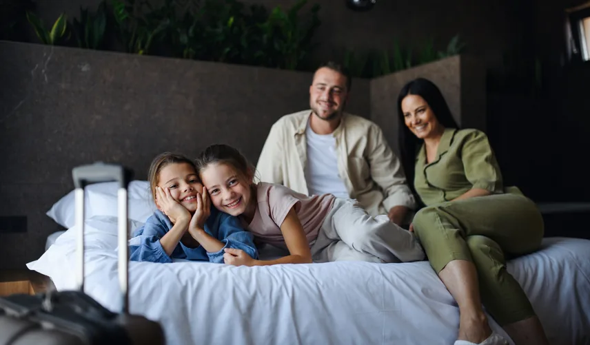Family staying in a UK hotel room with luggage for UK hotel booking from the UAE through Arabiers travel agency rates