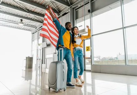 Travellers arriving in the USA with luggage at an airport, selected by Arabiers for USA hotel booking and B1/B2 visa guidance from the UAE