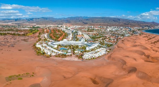 Qasr Al Sarab Desert Resort by Anantara surrounded by palm trees and traditional Arabian architecture