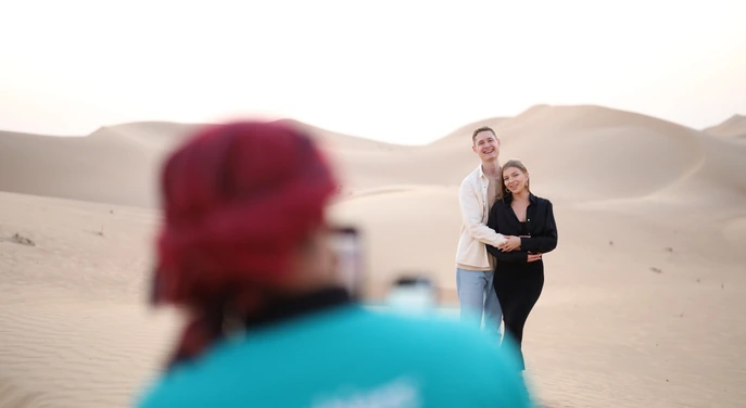 Couple taking photographs among the Abu Dhabi dunes during a private desert experience