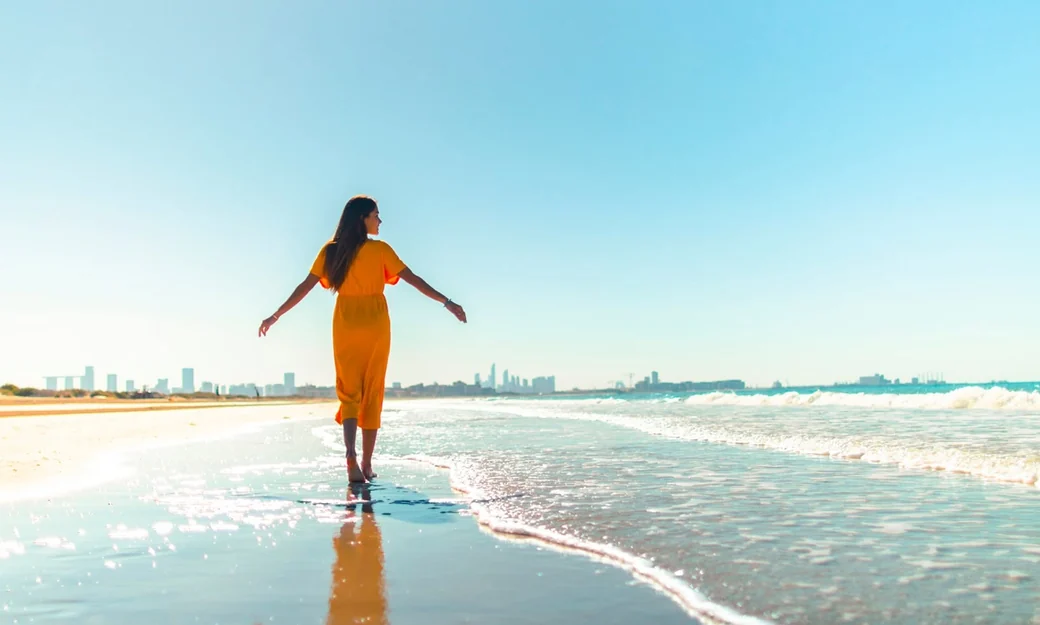 Visitor walking along the Abu Dhabi Corniche beach
