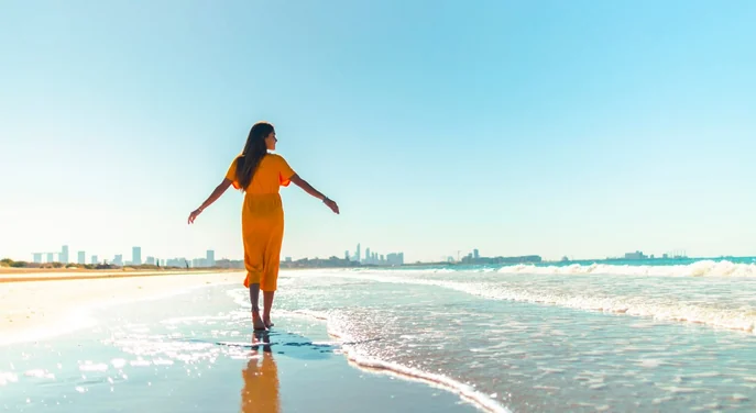 Visitor walking along the Abu Dhabi Corniche beach