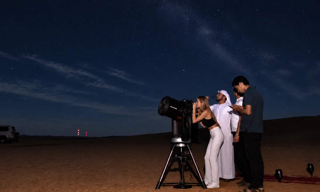 Guests enjoying telescope stargazing under the night sky at Al Quaa desert in Abu Dhabi