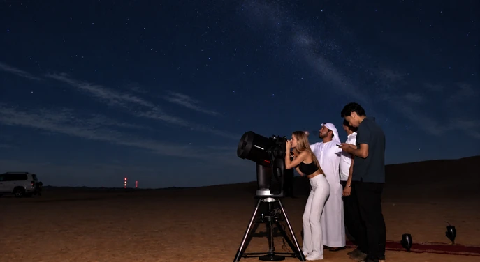 Guests enjoying telescope stargazing under the night sky at Al Quaa desert in Abu Dhabi