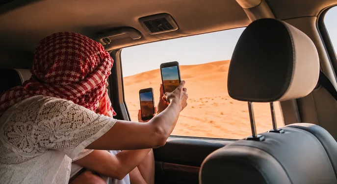 Traveller photographing the Abu Dhabi dunes from a private 4x4