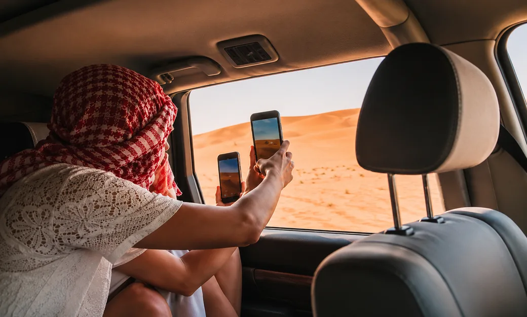 Traveller photographing the Abu Dhabi dunes from a private 4x4