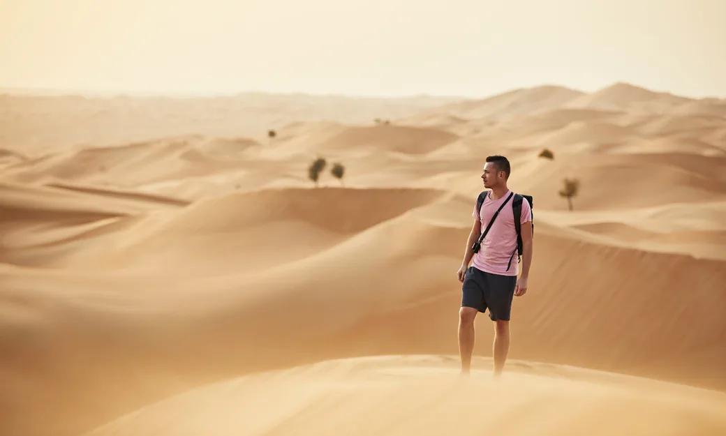 Guests walking with a Bedouin guide across the open Abu Dhabi desert