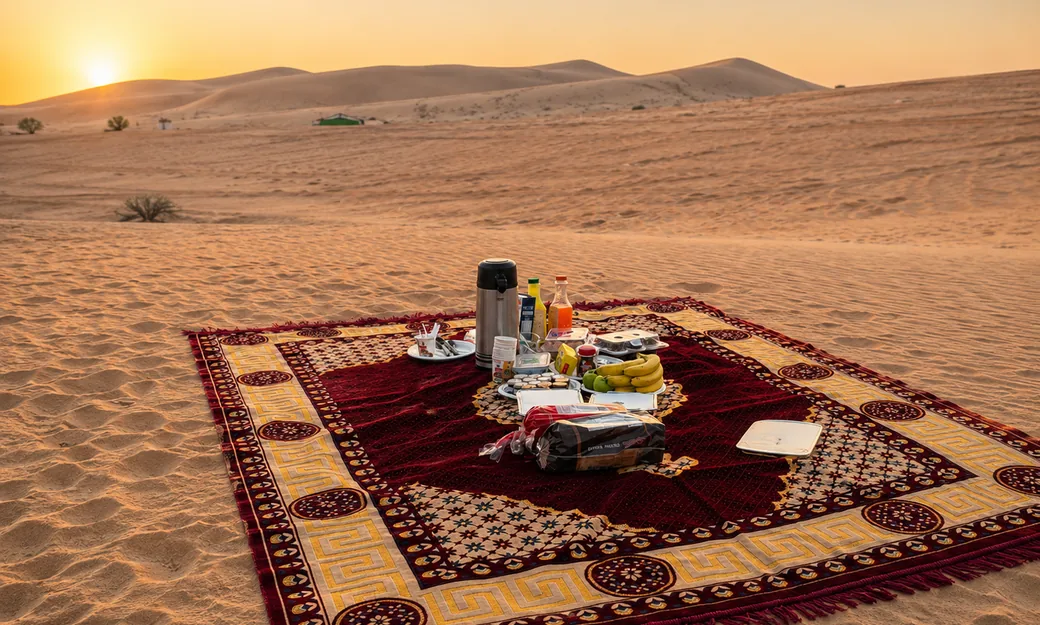 Outdoor breakfast prepared on a carpet in the Abu Dhabi desert
