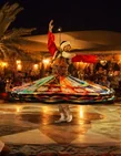 Guests watching a colourful tanoura show at the desert camp