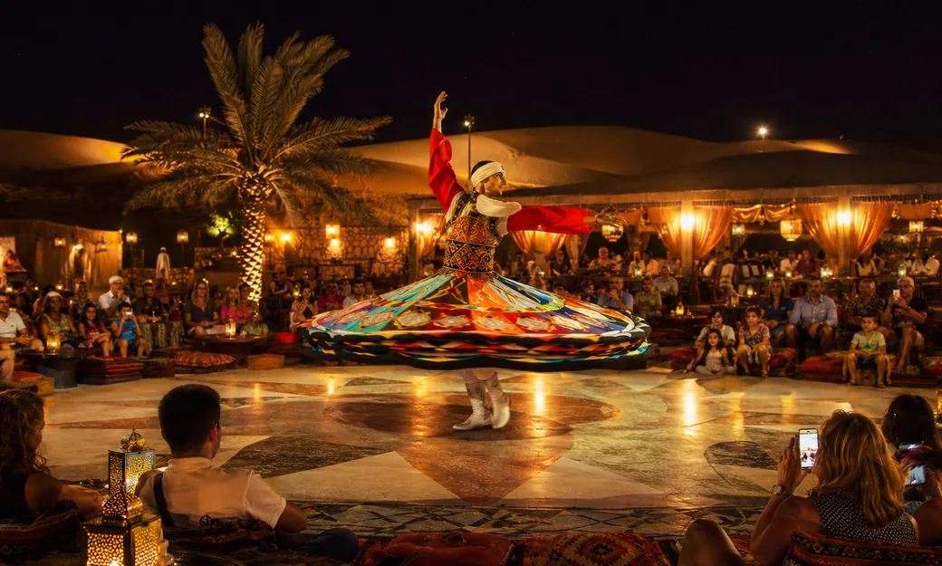 Guests watching a colourful tanoura show at the desert camp