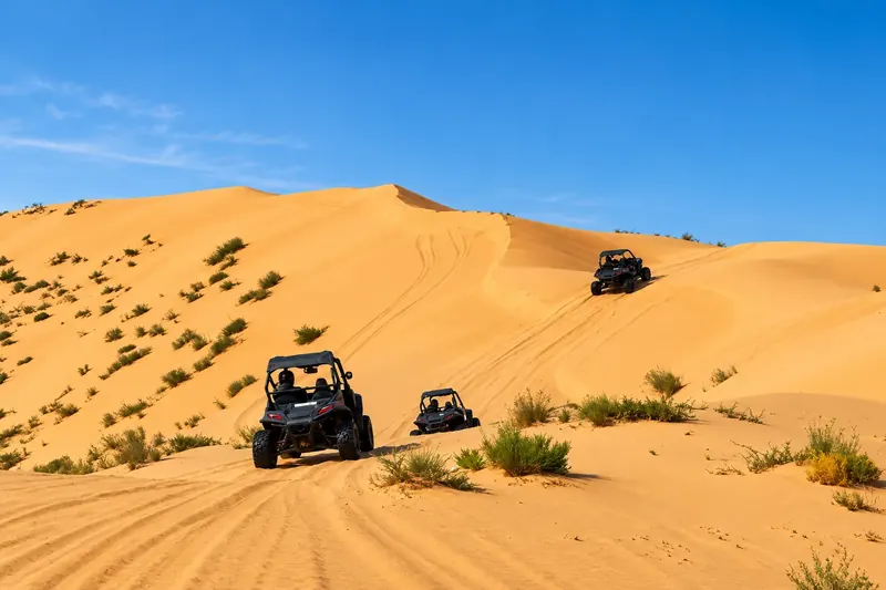 Three dune buggies on the red dunes of Al Khatim, Abu Dhabi