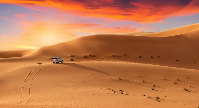 Private 4x4 crossing Abu Dhabi dunes beneath a dramatic evening sky